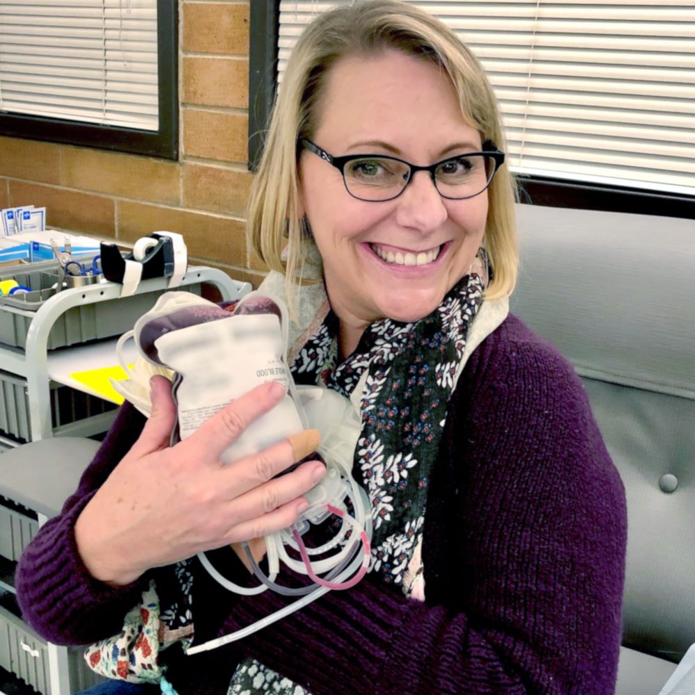 A photo of Barb holding a blood bag