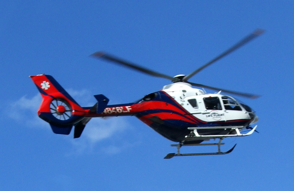 Life Flight Network helicopter in flight against a blue sky